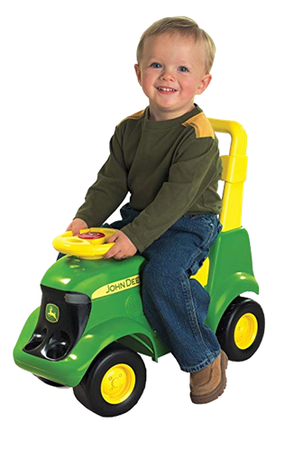 A smiling toddler on a toy green tractor